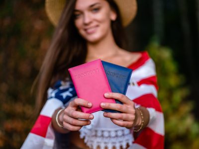 Happy woman in a straw hat with an american flag and passports i